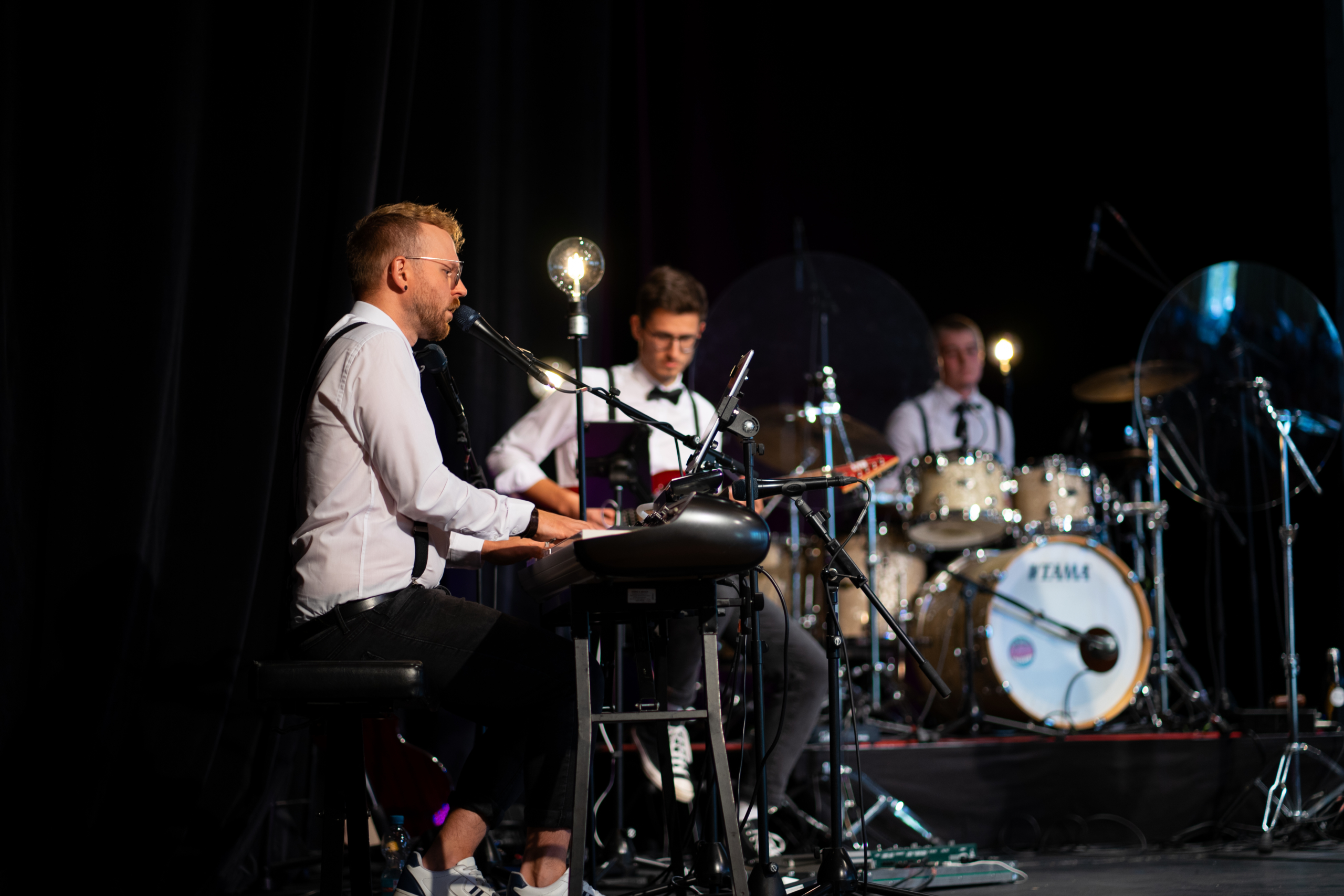 Das Bild zeigt die Band WeChazz, im Vordergrund ein Klavierspieler, im Hintergrund Gitarrist und Schlagzeuger